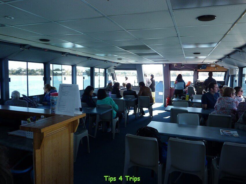 tables and chairs inside the boat of a Dolphin Mandurah Cruise