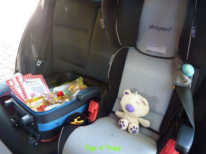 bag of toys next to kids car seat onroute to self catering vacation rental