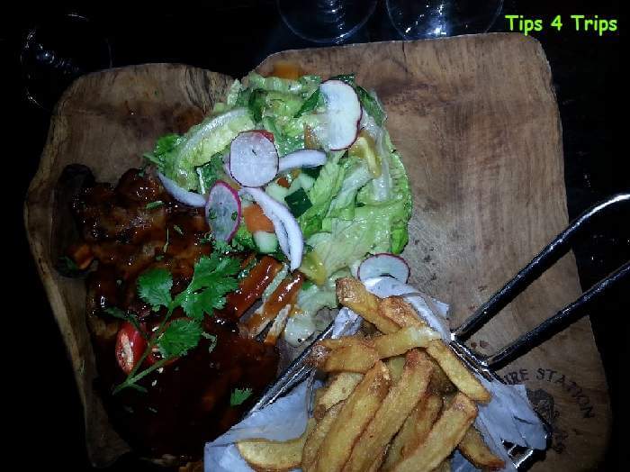 Ribs, chips and salad served on a board at the Fire Station Restaurnt in Sanur, Bali