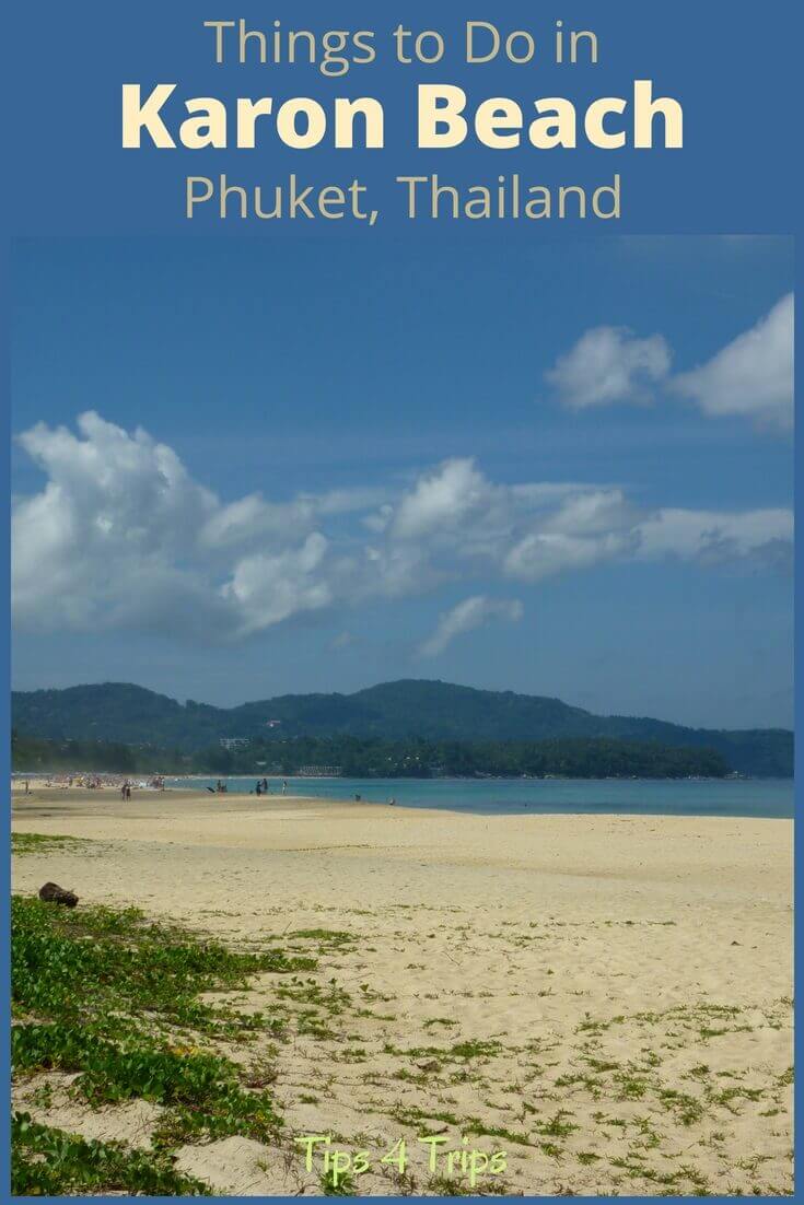 The beach at karon in Phuket with golden sands, blue water and mountains on the horizon