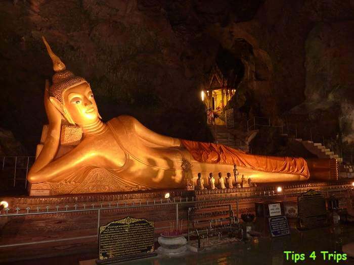 Long gold reclining buddhe in the cave temple of Wat Suwan Kuha