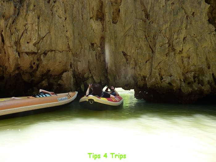 Canoe through low limestone caves in Phang Nga Bay
