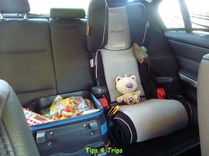 An activity bag next to kids carseat prepared for long road trip