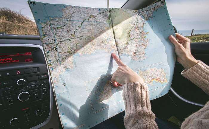 A lady pointing to a road map planning trip
