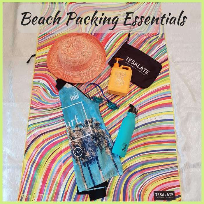 beach towel, rashie, goggles, sunscreen and waterbottle all essentials to pack for the beach