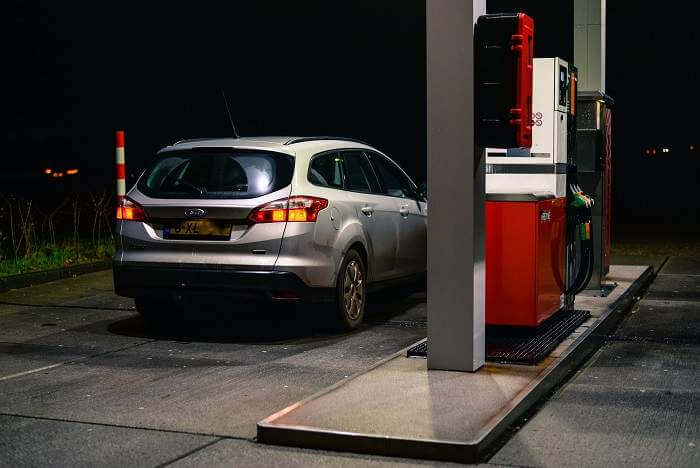 car parked at fuel station at night before long road trip