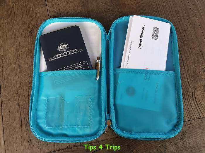blue document wallet with passport pen and tickets