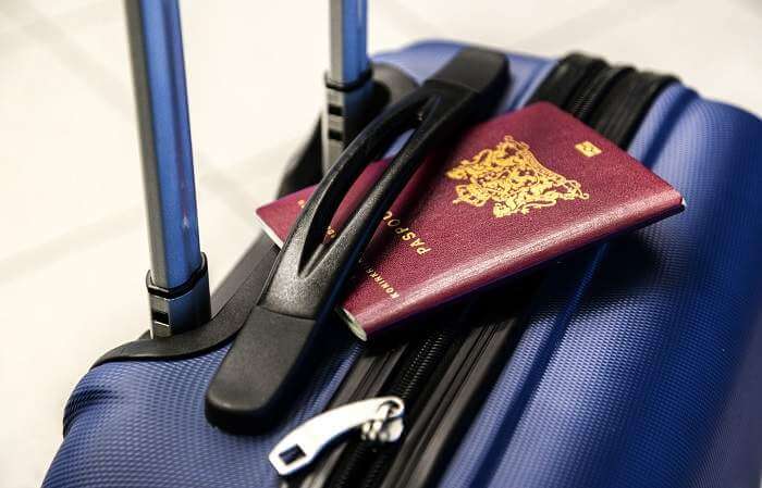purple wheeliw hand carry suitcase with passport