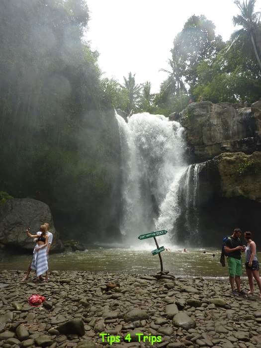 people swimming at the base of the waterfall and sign reading "it's ok to be sexy but no naked"