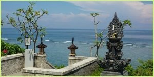 bali stone statue looking out to blue sea