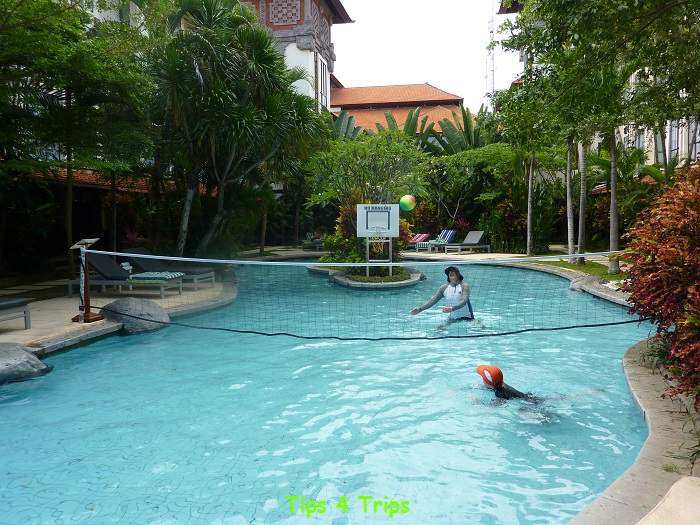 Two people in Bali pool with hats and rash guard clothing protecting from sun