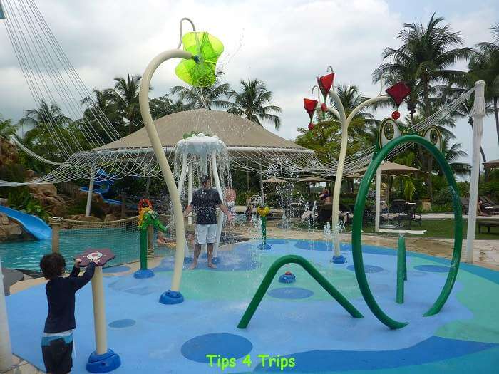 father and son playing in water playground at resort