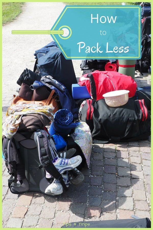 two backpacks on the ground with lots of shoes and camping equipment attached