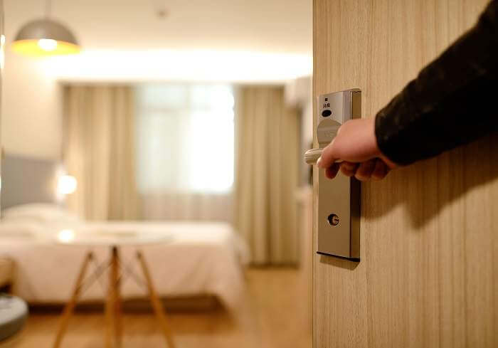man opening door to hotel room