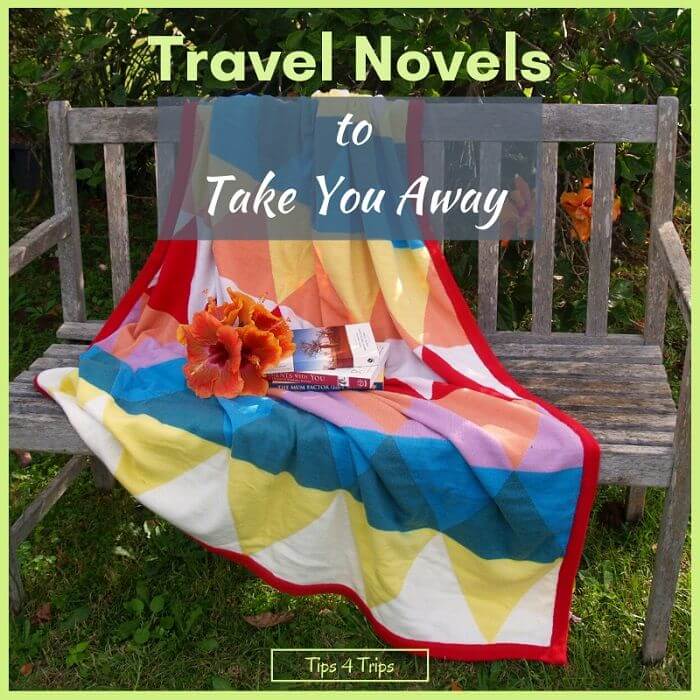 grey timber park bench with coloured patchwork quilt and travel novel to read