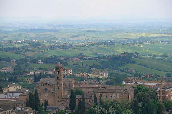 overlooking Tuscan town with church steeple to fields