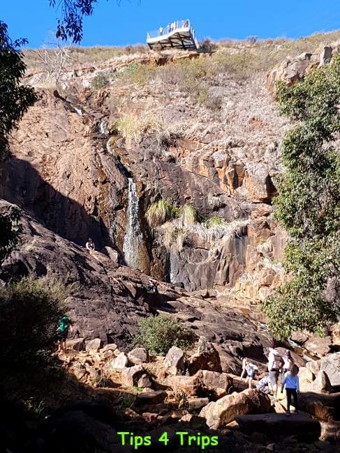 people climbing over rocks at the bottom of Lesmurdie Falls, Perth