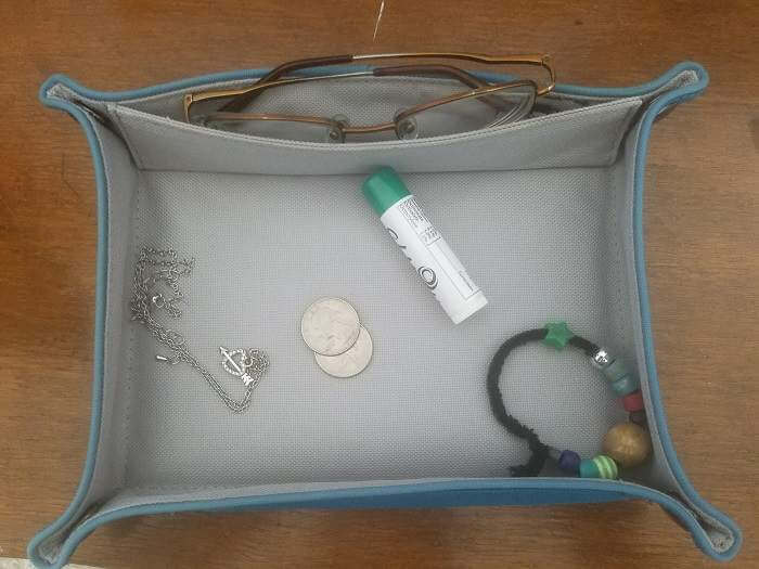 cloth tray with jewellery, glasses and coins