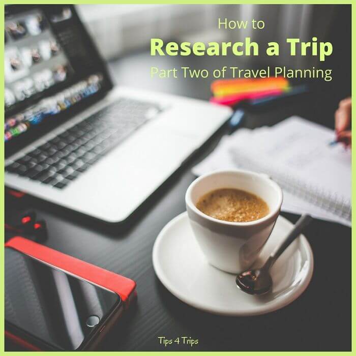taking notes in front of a computer as researching a trip