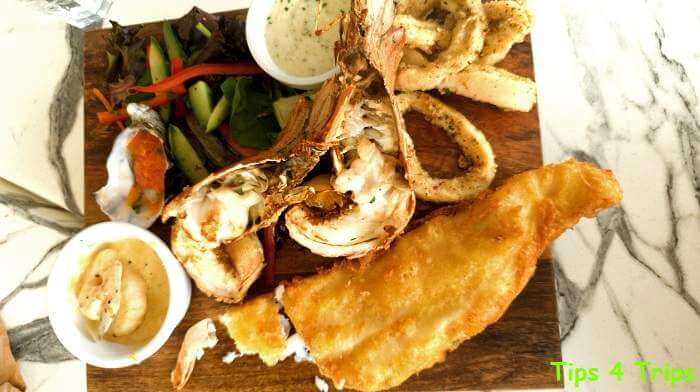 fried fish, Morton Bay Bugs, squid on a wooden board