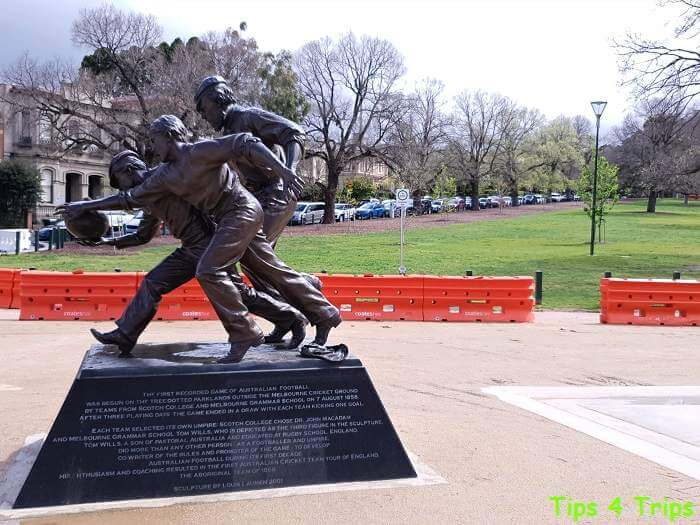 bronze statue of three men playing AFL at MCG