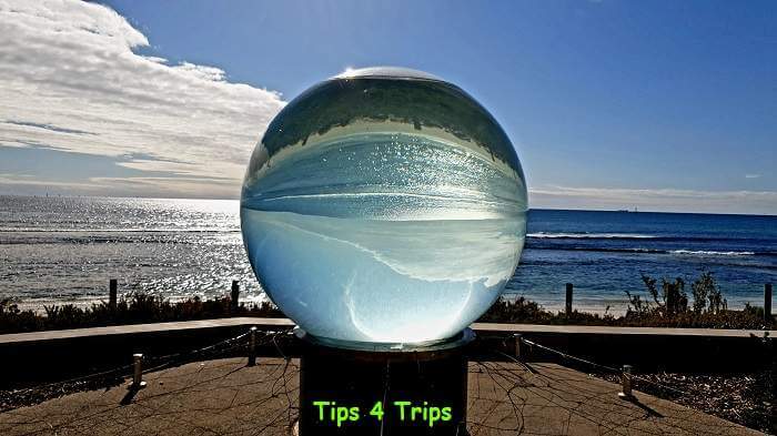 big glass ball with reflection of ocean upside down