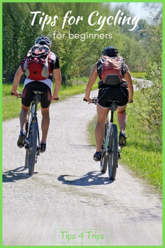 two people cycling on a dirt road with back packs