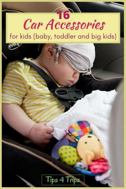 baby sitting in car asleep surrounded by kids car accessories