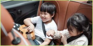 boy and girl sitting in the back of car with car toys