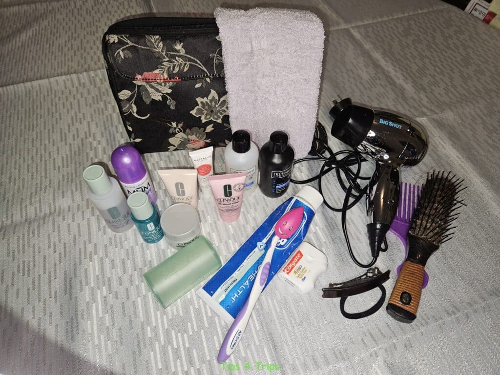 My essential travel toiletries consisting of toothbrush, toothpaste, facial cleansers, moisturiser, hairbrush, comb and small hair dryer