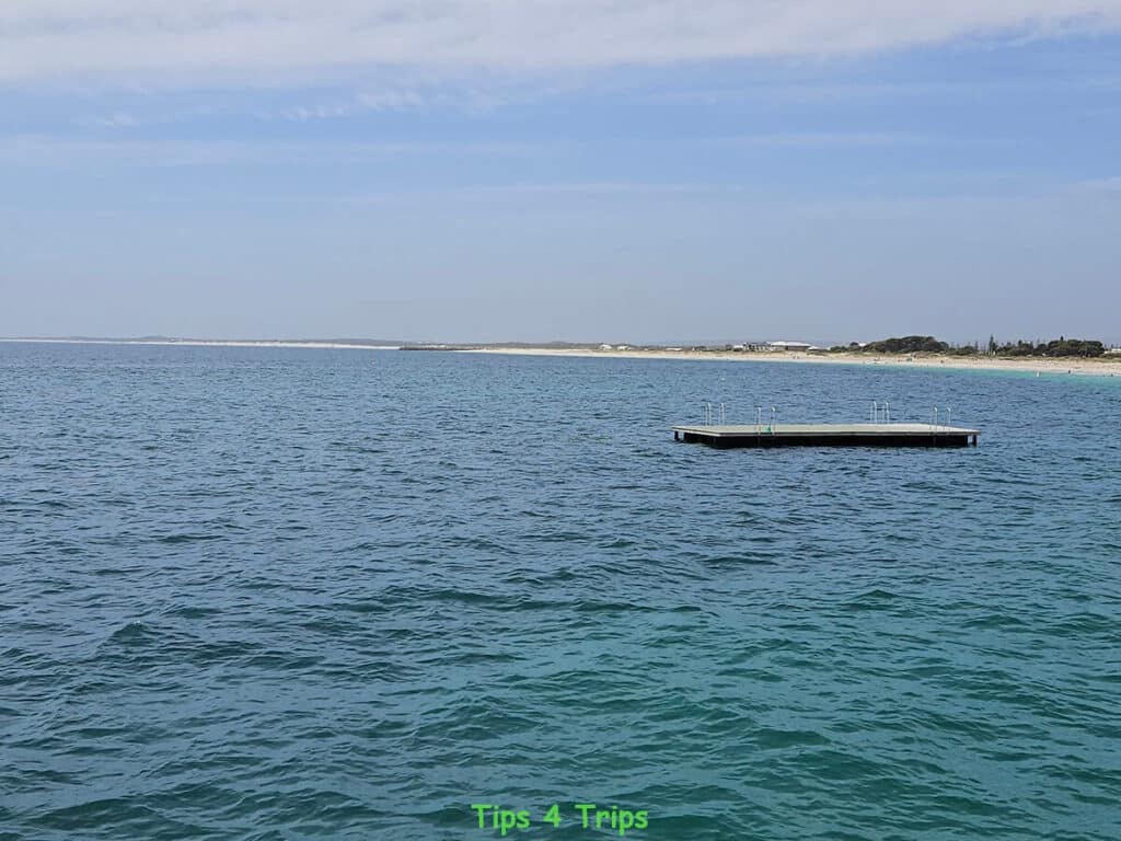 Looking across Jurien Bay waters back to shoreline with swimming pontoon in foreground